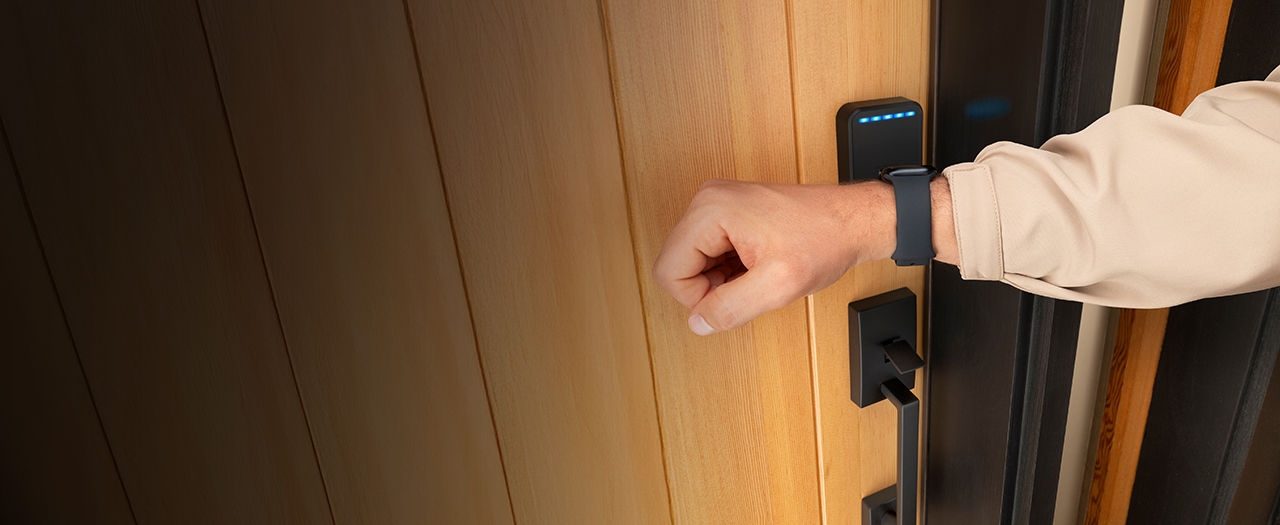 Man uses Apple watch with Schlage Sense Pro Apple home key smart lock for tap to unlock