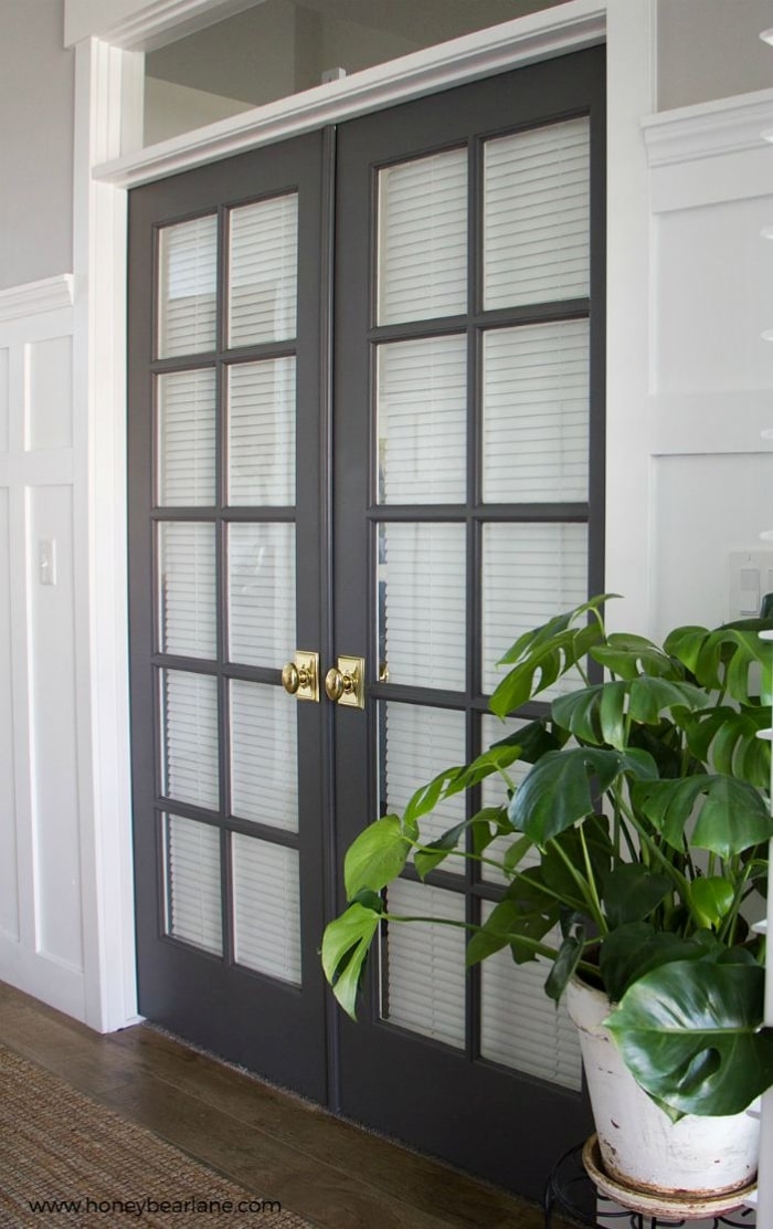 Charcoal grey French doors with Bright Brass door knobs.