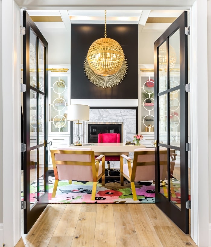 Black French doors leading into bright home office.