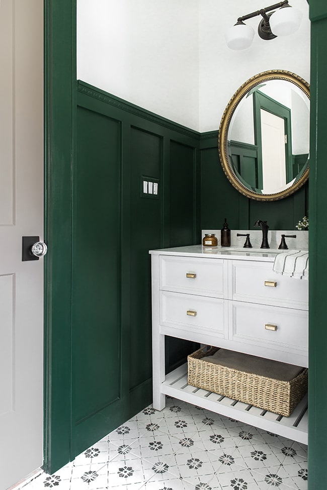 Green bathroom with black and gold finishes.