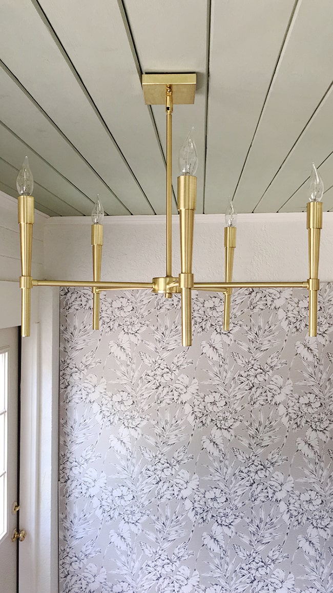Gold chandelier in laundry room mudroom.