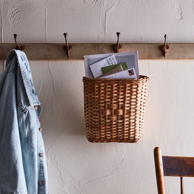 Hanging rattan basket holding mail.