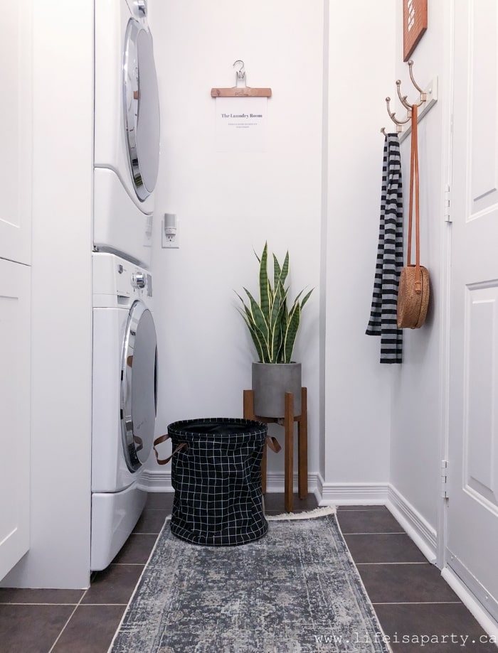 Mudroom laundry room with laundry hamper.