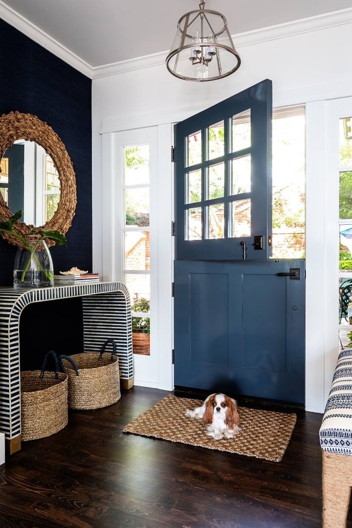 Country cottage style entryway with dark blue dutch door.