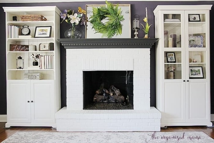White brick fireplace with mirror above mantel.
