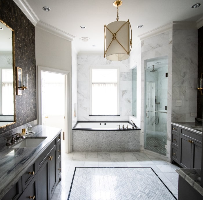 Luxurious marble bathroom with tile rug.