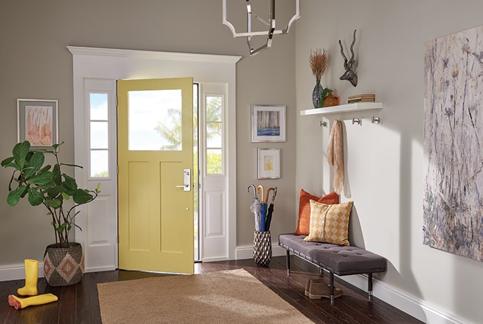 Foyer with yellow front door and Schlage Custom handleset in Bright Chrome.