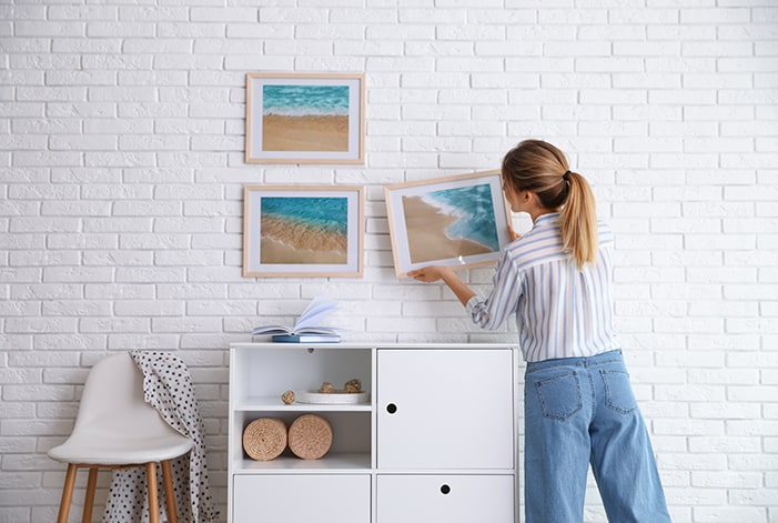 Woman hanging picture frames.