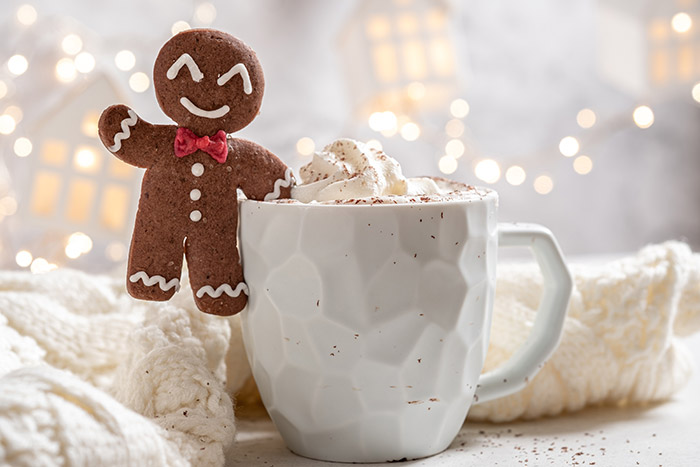 Gingerbread cookie sitting on mug of hot chocolate.