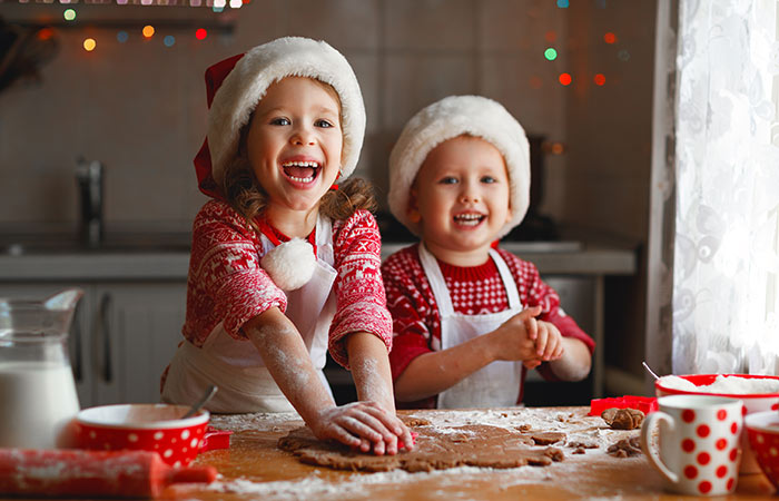 Happy children baking Christmas cookies.