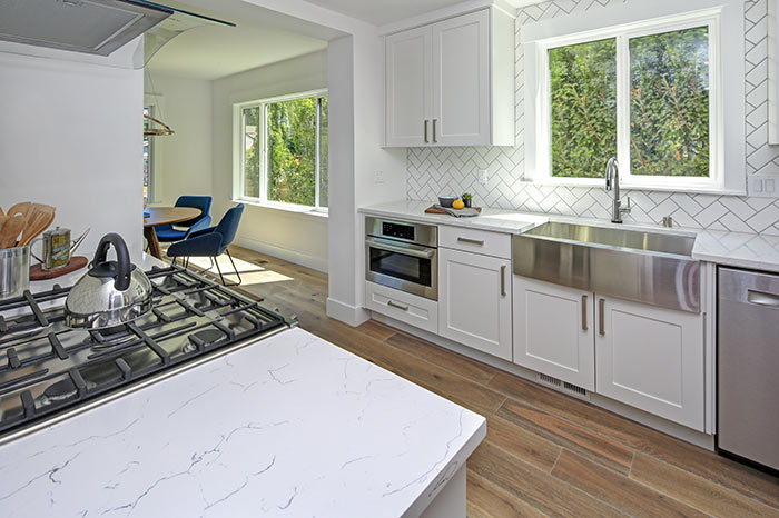 White kitchen with herringbone backsplash tile.