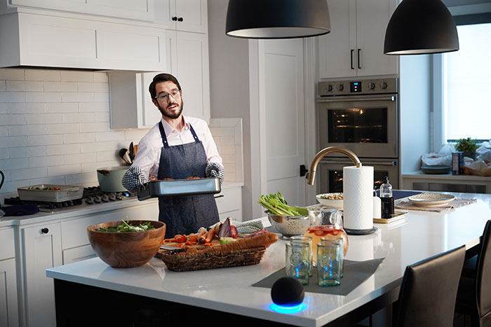 man-cooking-dinner-speaking-to-amazon-alexa-speaker