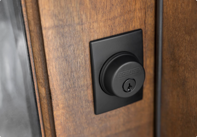 Close up of a black keyed deadbolt on a wooden front door