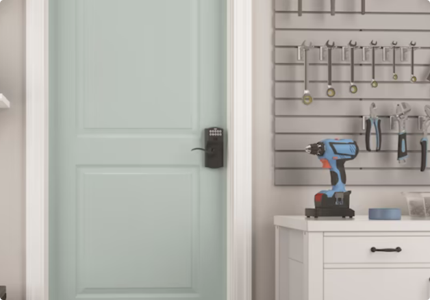 Garage with a tool bench and a door to the home featuring a keyless electronic lock