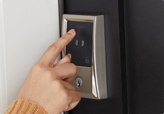 Close up of a person's hand entering a code on a smart lock