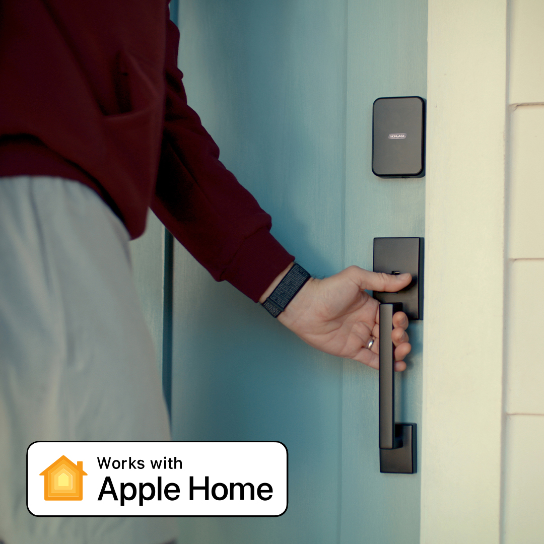 Un homme entre dans la maison avec une serrure intelligente Schlage Sense Pro compatible Apple Home Key avec UWB pour déverrouiller la porte à l’aide d’une Apple Watch