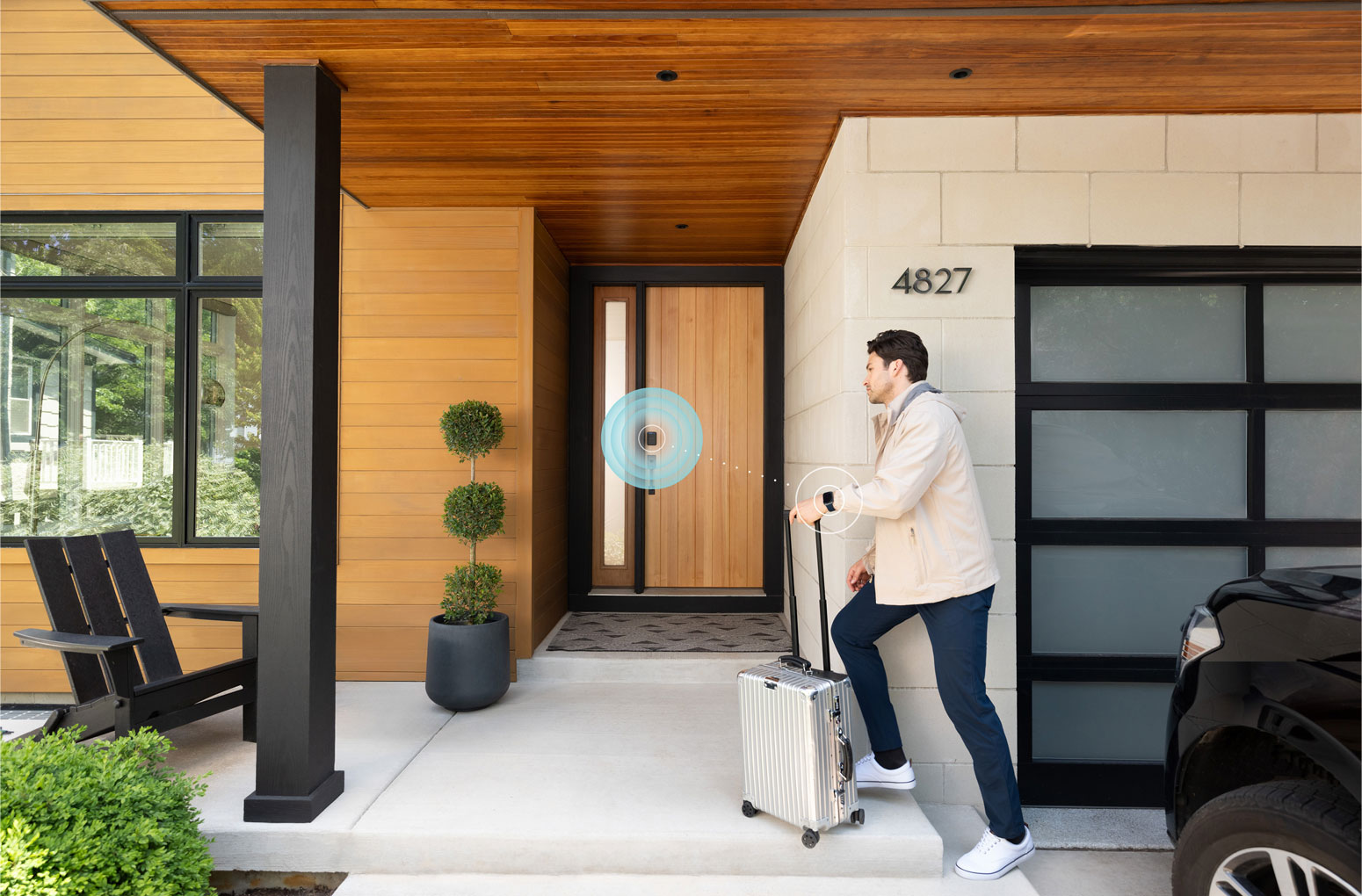 Un homme avec une valise franchit la porte d’entrée en utilisant la serrure intelligente Schlage Sense Pro à ultra‑large bande pour déverrouiller la porte avec une Apple Watch