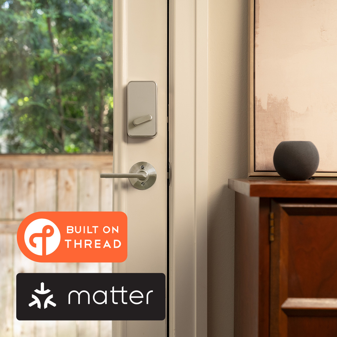 Schlage Sense Pro Matter over Thread smart lock on door next to a table with a Thread-enabled Apple home pod